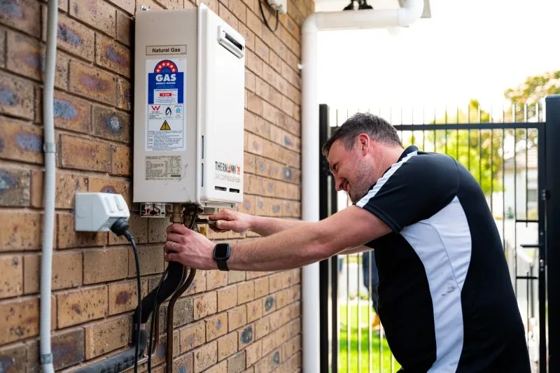 King & Sons plumber servicing a gas hot water system